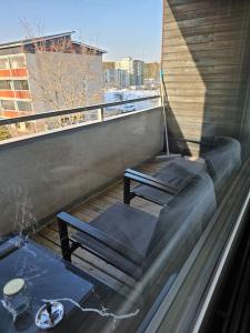 d'un balcon avec deux bancs, une table et une fenêtre. dans l'établissement Miller Apartment - Free parking, airport 21min, à Klaukkala