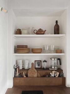a shelf with plates and bowls and other kitchen items at Maison Magda in Ambierle