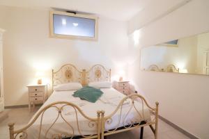 una camera con letto bianco e specchio di Casa Aleatico Residence Torre Santo Stefano in Otranto ad Alimini