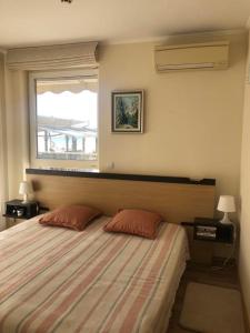 een slaapkamer met een bed met 2 kussens en een raam bij Obzor Beach Resort Beachfront in Obzor
