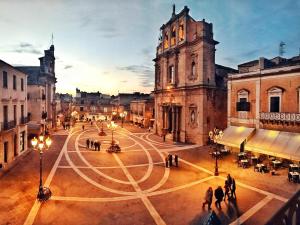 a group of people walking around a city street at night at Casa del pittore in Niscemi
