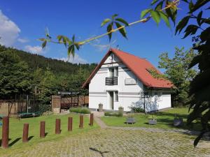 ein weißes Haus mit einem roten Dach in der Unterkunft Parysówka dom w Rzeczce Góry Sowie do 10 osób in Walim