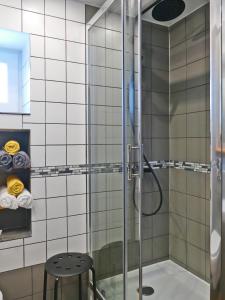 y baño con ducha de cristal con taburete. en Parysówka Noclegi w Rzeczce Góry Sowie en Walim