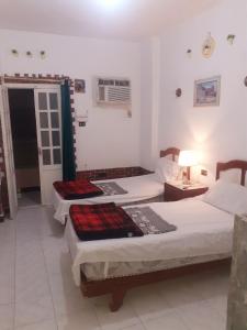 a bedroom with two beds and a table and a lamp at Four Seasons Hotel in Hurghada