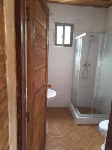 ein Bad mit einer Dusche, einem WC und einem Waschbecken in der Unterkunft Beachbungalows STP in M. Peixe