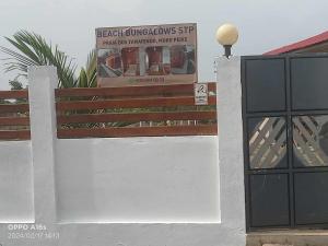 eine weiße Wand mit einem Schild darüber in der Unterkunft Beachbungalows STP in M. Peixe
