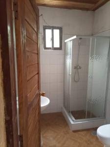 ein Bad mit einer Dusche, einem WC und einem Waschbecken in der Unterkunft Beachbungalows STP in M. Peixe