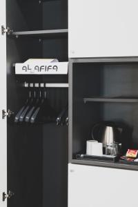 Elle comprend une petite cuisine équipée d'un réfrigérateur noir et blanc. dans l'établissement Hôtel AL AFIFA, à Dakar