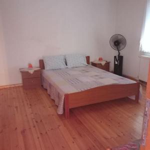 Quiet furnished millwork House. في Néa Zíkhni: سرير في غرفة مع أرضية خشبية