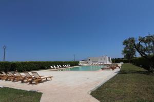 una piscina con sedie a sdraio accanto al resort di Casa Aleatico Residence Torre Santo Stefano in Otranto ad Alimini