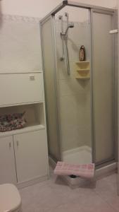 een douche met een glazen deur in de badkamer bij Casa del Capitano in Villasimius
