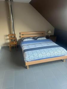 una camera con letto e sedia in legno di Le Petit Parc a Wavre