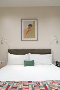 達喀爾的住宿－Hôtel AL AFIFA，卧室配有带两盏灯的白色床