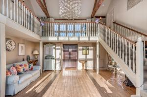 a living room with a staircase and a couch at Luxurious, Fabulous, Fun, Contemporary Suite in Retreat Centre in Salisbury