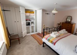 a bedroom with a bed and a chair in it at Dene Croft Cottage in Hexham