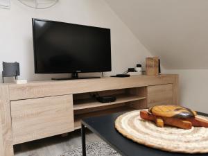 a living room with a tv and a table at Gite du Persil - Meublé de Tourisme 3 étoiles in Le Mesnil-Simon
