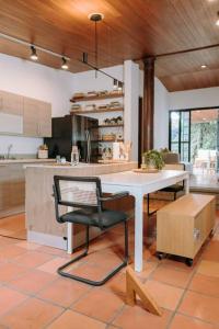 a kitchen with a white table and a chair at RN Villa - San Benito in San Salvador