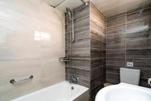bagno con vasca e servizi igienici di Helios Bay Hotel and Suites a Paphos