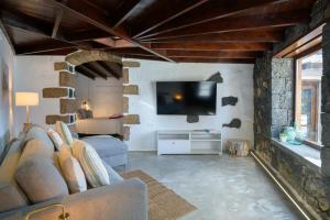 a living room with a couch and a tv at La Casa del Medianero in Mácher