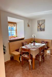 een eetkamer met een tafel en stoelen en een raam bij Dolomites Charme Chalet in Colle Santa Lucia