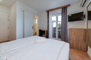 Bed & Breakfast Došen II في باشكا: غرفة نوم بسرير ابيض كبير ونافذة