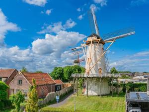 a windmill in a yard with a house at Strandhotel Wemeldinge in Wemeldinge +5 photos