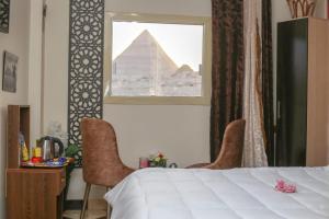 a bedroom with a bed and a view of the pyramids at pyramids show hotel in Cairo