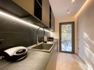 a modern kitchen with a sink and a window at Platinum River Apartments in Potamós