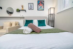 una camera da letto con un grande letto bianco con cuscini verdi di Highbury & Islington Hub a Londra