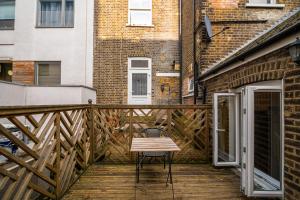 un balcone in legno con panca su una terrazza di legno di Highbury & Islington Hub a Londra