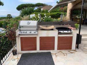 a outdoor kitchen with a grill and a stove at Villa les Cades in Sainte-Maxime