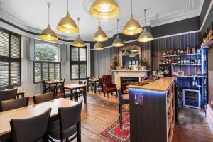 um restaurante com mesas e cadeiras e uma lareira em Ravilious em Eastbourne