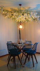 a dining room table with blue chairs and a chandelier at RR Residence in Viana do Castelo