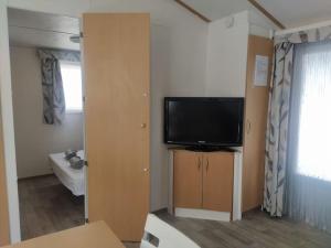a living room with a flat screen tv on a cabinet at Bungalow, Sueños del Sur! in Chiclana de la Frontera