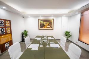 a conference room with a long table and white chairs at Hotel Corregidor by Cassana in Arequipa