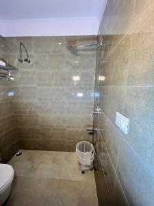 uma casa de banho com um chuveiro, um WC e um balde em Cosy stay em Haldwani
