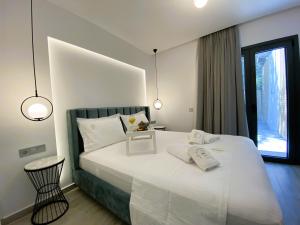 una camera da letto con un grande letto bianco e una finestra di Platinum River Apartments a Potamós