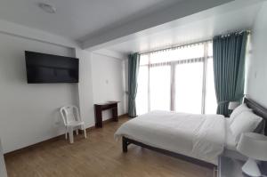 um quarto de hotel com uma cama e uma televisão em La Casa de Algodon em Huacho