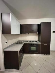 una cucina con armadi marroni e piano cottura. di Sottomarina Sabbia e Sale a Sottomarina