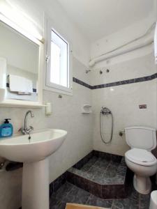 uma casa de banho com um lavatório, um WC e uma janela. em Villa Zefiros em Kypri