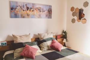 ein Schlafzimmer mit einem Bett mit bunten Kissen in der Unterkunft Casa Zoe 2 Apartment(Parking,Self Check-in & Wi-Fi) in Parma
