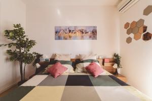 ein Schlafzimmer mit einem großen Bett mit bunten Kissen in der Unterkunft Casa Zoe 2 Apartment(Parking,Self Check-in & Wi-Fi) in Parma