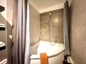 een badkamer met een toilet en een douche met een douchegordijn bij Appartement de standing- hyper centre in Sens