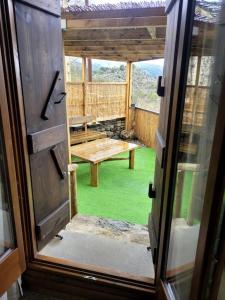 an open door to a porch with a picnic table at El Pajar de la Plaza in Guaso