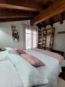 um quarto com uma cama com almofadas e uma escada em El Pajar de la Plaza em Guaso