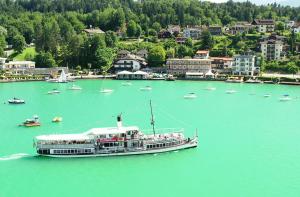 een boot op een grote hoeveelheid water met boten bij Beachhaus Velden in Velden am Wörthersee