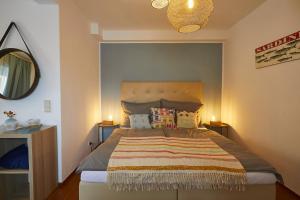 een slaapkamer met een groot bed en een gestreepte deken bij Beachhaus Velden in Velden am Wörthersee