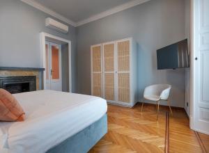 米兰Fifty Eight Suite Milan Center的一间带床、电视和椅子的卧室