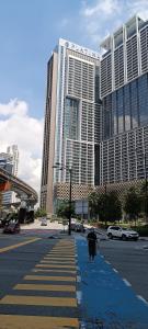 a person walking down a street in front of buildings at SKYWARD SUITE KLCC in Kuala Lumpur