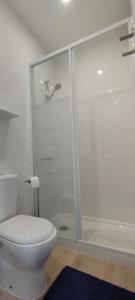 a white bathroom with a toilet and a shower at Ribeiro´s House in Gafanha da Nazaré